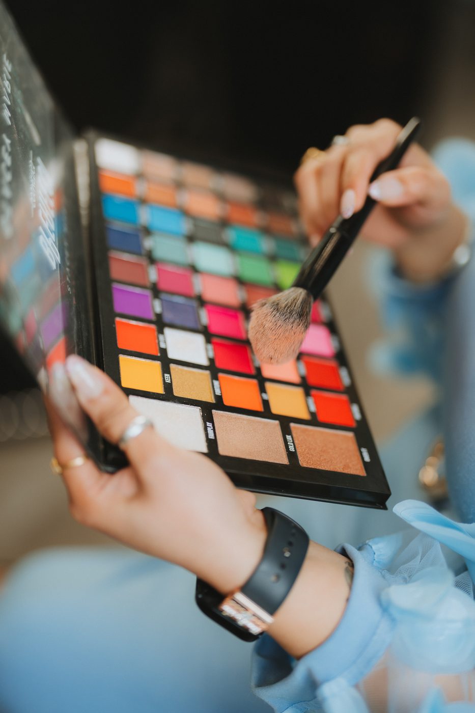 Makeup artist selecting eyeshadow from a palette at Beauty with Grace