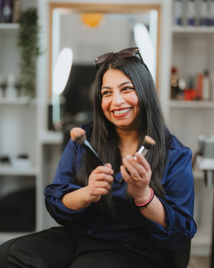 Makeup artist at Beauty with Grace holding makeup brushes