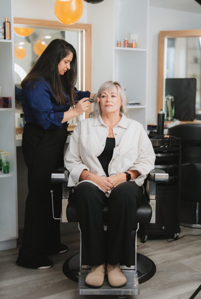 Pam applying makeup to a client at Beauty With Grace in Christchurch